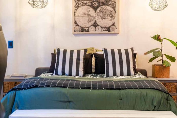 Ocean Room bedroom with king bed and world map in the Main Villa