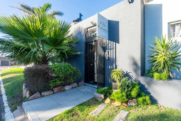 Palm-shaded entrance gate to Villa Palmera guesthouse